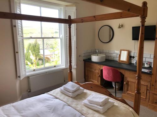 a bedroom with a bed and a sink and a window at Giltar Grove Country House in Tenby