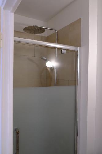 eine Dusche mit einer Glastür in einem Badezimmer in der Unterkunft Le Clou in Chauvigny