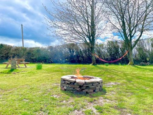 een vuurplaats in het midden van een veld bij Luxury, Spacious Cottage in the Black Mountains in Hereford