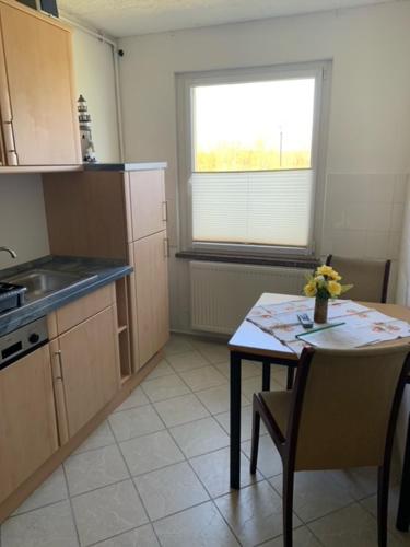 een kleine keuken met een tafel en een raam bij Ferienpark Buntspecht Apartment 1 in Pruchten