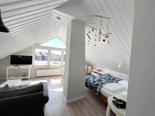 um quarto com uma cama e uma sala de estar em Herzmuschel em Hörnum
