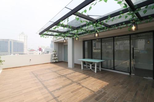 a rooftop patio with a green table on a building at Flamenco Urban Living in Jakarta