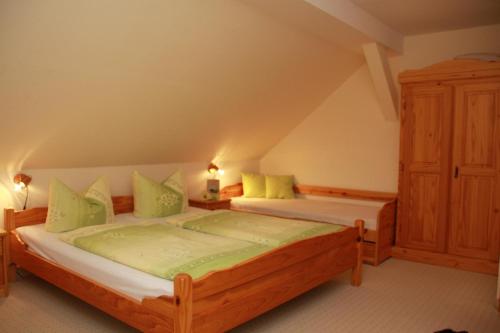 een slaapkamer met 2 bedden en groene kussens bij Ferienhof Schönfelder in Königstein an der Elbe