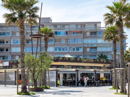 un bâtiment avec des palmiers devant dans l'établissement Apartment Ipanema Sud-6 by Interhome, à Canet