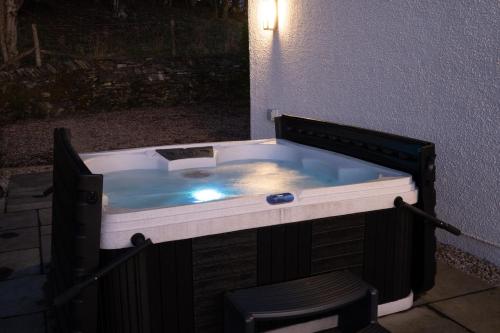 a hot tub in the corner of a building at Cleabarrow View in Windermere