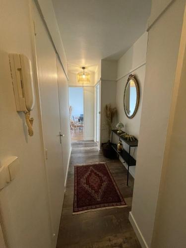 a hallway with a white door and a rug at Les Petites Fécampoises by Mathilde in Fécamp