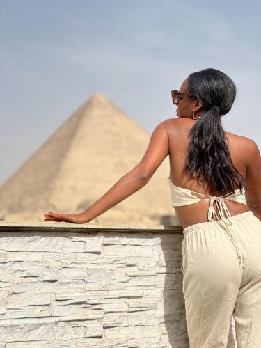 a woman standing in front of the pyramids at Pyramids top success result in Cairo