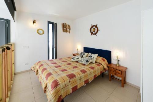 um quarto com uma cama e uma mesa com um relógio na parede em Dúplex Luminoso en el centro de CADAQUÉS em Cadaqués