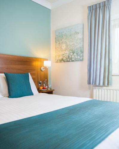 a hotel room with a bed and a window at Last Drop Village Hotel & Spa in Bolton