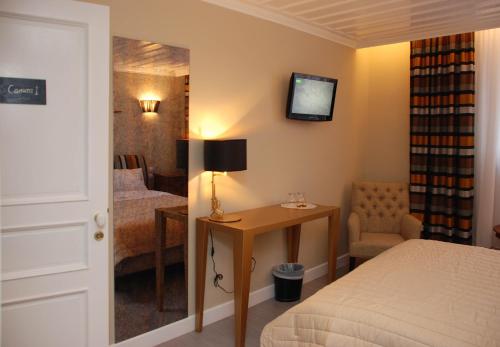 a bedroom with a bed and a table and a mirror at il Palazzo Rooms & Suites in Nafplio
