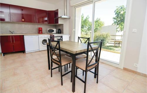 a kitchen with a table and chairs in a kitchen at Le Jardin in Le Sambuc