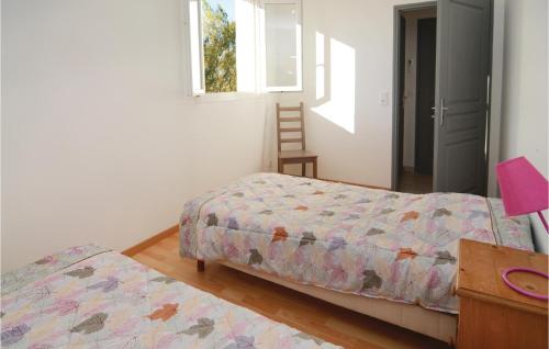 a bedroom with two beds and a window and a chair at Le Jardin in Le Sambuc