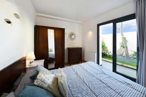 ein Schlafzimmer mit einem großen Bett und einem großen Fenster in der Unterkunft Apartamento luminoso en el centro de CADAQUÉS in Cadaqués