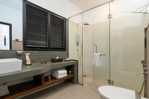 a bathroom with a glass shower and a sink at Jetwing Mahesa Bhawan in Jaffna