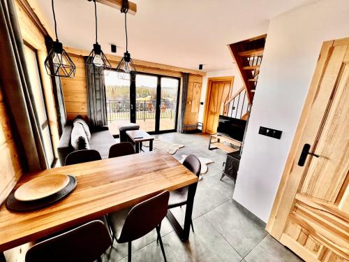 - une salle à manger avec une table et des chaises en bois dans l'établissement Tatra Village, à PyzÃ³wka