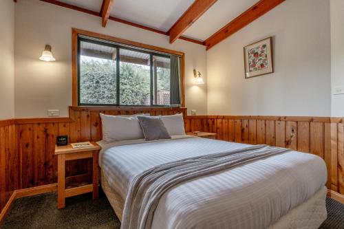 una camera da letto con un letto grande e una finestra di Freycinet Cottage 1 – Bluestone a Coles Bay
