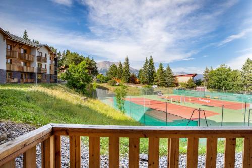 - une vue sur un court de tennis depuis la terrasse dans l'établissement SOWELL RESIDENCES Pra Loup, à Pra-Loup