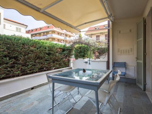 a glass table and two chairs on a balcony at Apartment Cristina by Interhome in Riva Ligure