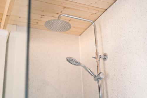 a shower with a shower head in a bathroom at The Snug, Cromer, a short walk to the beach. in Cromer