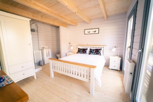 um quarto com uma cama branca e piso em madeira em The Snug, Cromer, a short walk to the beach. em Cromer