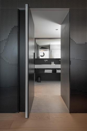 a bathroom with a large mirror and a sink at Hôtel des Horlogers in Le Brassus