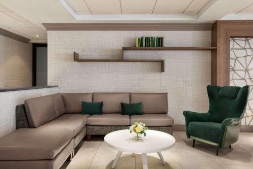 a living room with a couch and a table and chairs at Wyndham Garden Totowa in Totowa