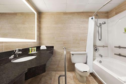 a bathroom with a sink and a toilet and a tub at Wyndham Garden Totowa in Totowa