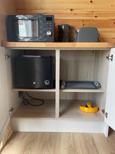 a shelf with a microwave oven and a microwave at Wall park touring Centry road camping in Brixham