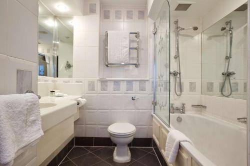 a bathroom with a toilet and a tub and a sink at Derby Mickleover Hotel, BW Signature Collection in Derby