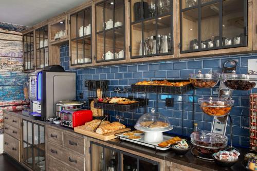 a kitchen with a bunch of food on a counter at Best Western Plus Hotel Canet-Plage in Canet-en-Roussillon