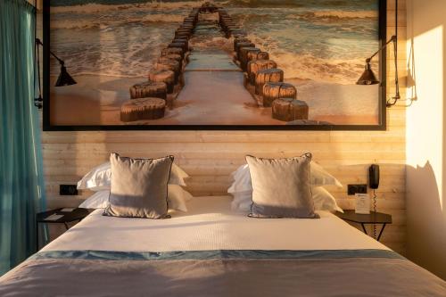 a bedroom with a bed with a painting on the wall at Best Western Plus Hotel Canet-Plage in Canet-en-Roussillon