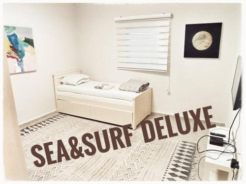 Un dormitorio con una cama con un cartel de "severeseveresevere" en el suelo. en Sea&Surf Deluxe Olga, en H̱adera