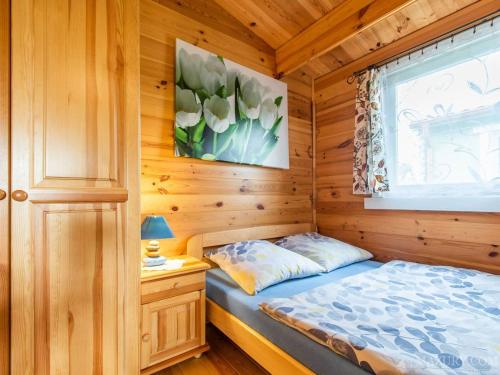 1 dormitorio con 1 cama en una cabaña de madera en Domki Romka en Mikołajki