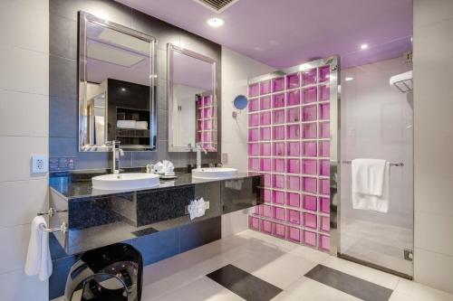 ein Bad mit 2 Waschbecken und einer Dusche in der Unterkunft Riu Plaza Panamá in Panama-Stadt