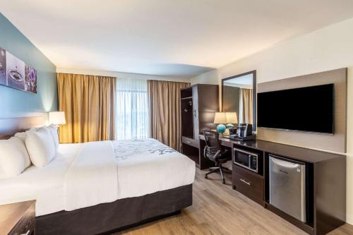 a hotel room with a bed and a flat screen tv at Sleep Inn on the Beach in Orange Beach