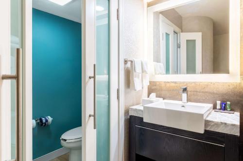 
a bathroom with a sink, toilet and shower at Sleep Inn on the Beach in Orange Beach
