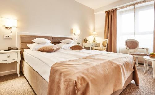 a bedroom with a large bed with white sheets at Continental Forum Tirgu Mures in Târgu-Mureş