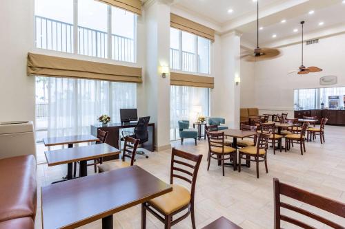 a restaurant with tables and chairs and windows at Sleep Inn on the Beach in Orange Beach