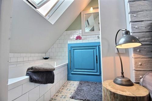 Łazienka z niebieskimi drzwiami i wanną w obiekcie La chambre du capitaine w mieście Plérin