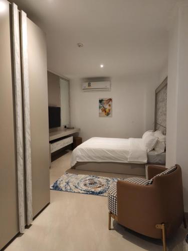a bedroom with a bed and a couch and a chair at Imperial Suites Hotel in Manama