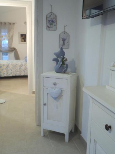 a small white cabinet with a blue stuffed animal on it at Le Bagnanti Suite in Orosei