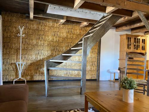 - un escalier en métal dans un salon avec une table dans l'établissement Herberg Boerderij de Straat-Hof, à Leimuiden