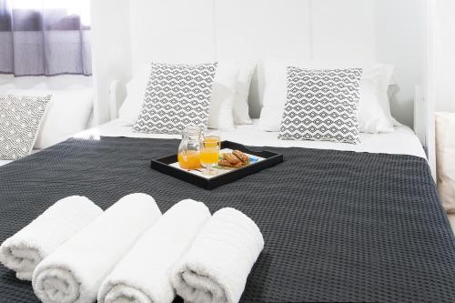 a tray of towels and glasses of orange juice on a bed at Bohemian Townhouse in Skiathos Town