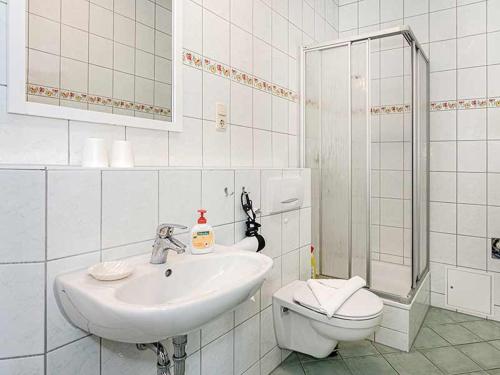 Un baño blanco con lavabo e inodoro. en Strandvilla Ostpreussen - Dependance Strandhus, en Ahlbeck