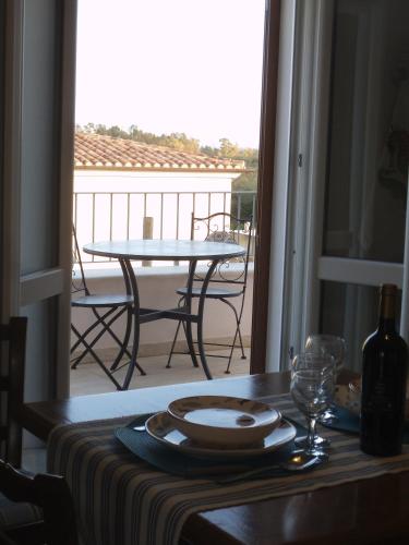 a table with a plate and wine glass on a balcony at Le Bagnanti Suite in Orosei