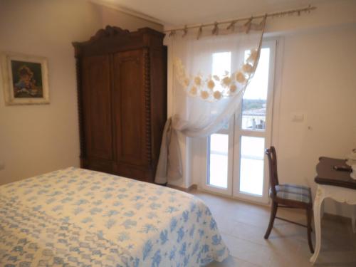 a bedroom with a bed and a window and a desk at Le Bagnanti Suite in Orosei