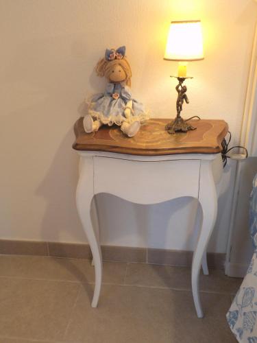 a teddy bear sitting on a table with a lamp at Le Bagnanti Suite in Orosei