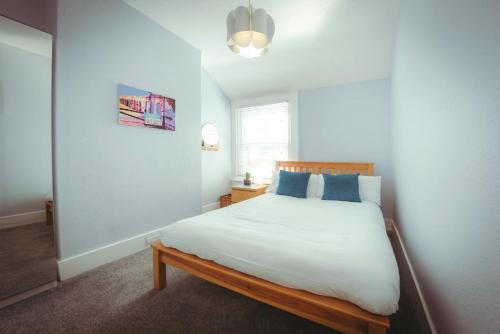 a bedroom with a large white bed with blue pillows at Old Town Cottage in Old Town