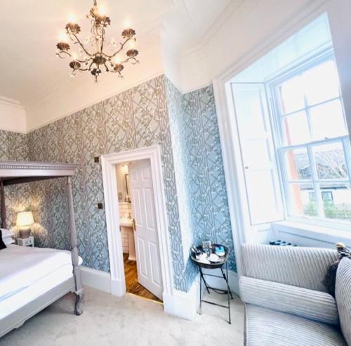 a bedroom with a bed and a window and a chandelier at Moffat House in Moffat
