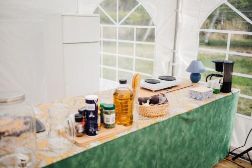 une table avec un tissu de table vert et des bouteilles dans l'établissement Le repère du pin sec - Glamping & Surfcamp, à Naujac-sur-Mer
